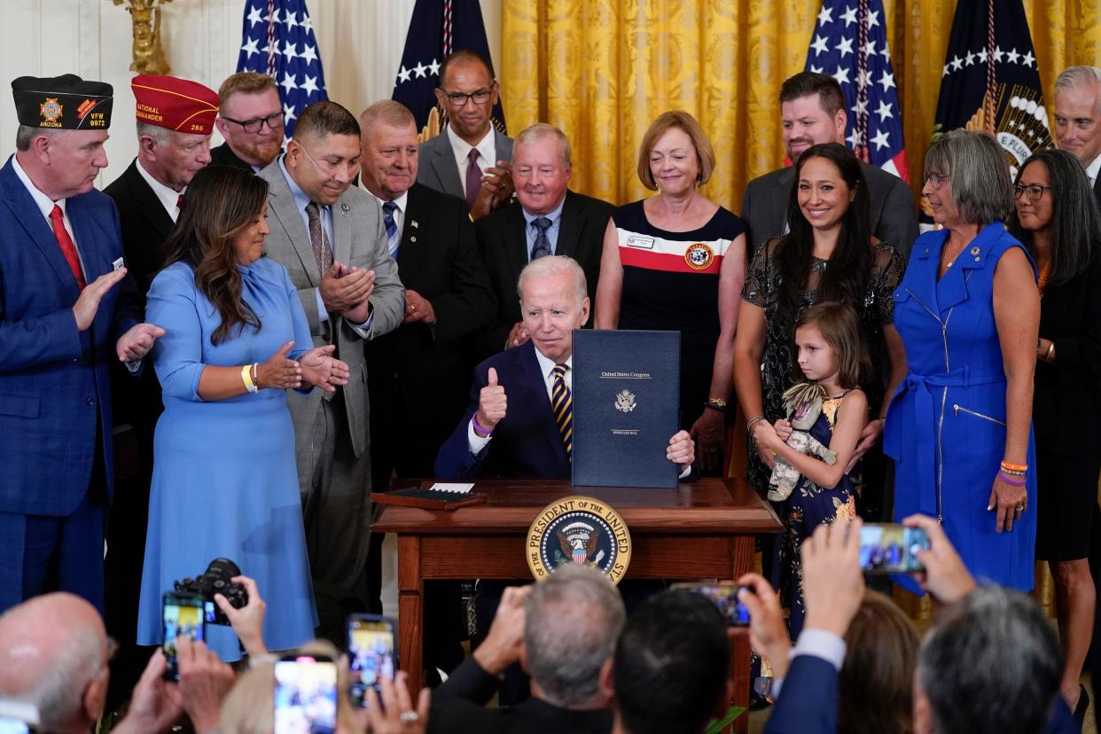 President Joe Biden holds the "PACT Act of 2022" after signing it during a ceremony in the East Room of the White House, Wednesday, Aug. 10, 2022, in Washington. 