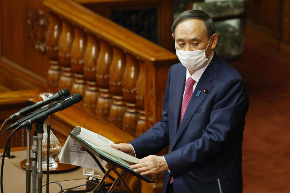 Japanese Prime Minister Yoshihide Suga, wearing a face mask, delivers a speech at the parliamentary session at the Upper House in Tokyo, Friday, Jan. 22, 2021. Japan is accelerating preparations for COVID-19 vaccinations in hopes of starting them in late February, but uncertainty is growing as the country faces vaccine-shy public, slow approval process and bureaucratic roadblocks, casting a doubt if Tokyo Olympic this summer is possible.(Masanori Takei/Kyodo News via AP)