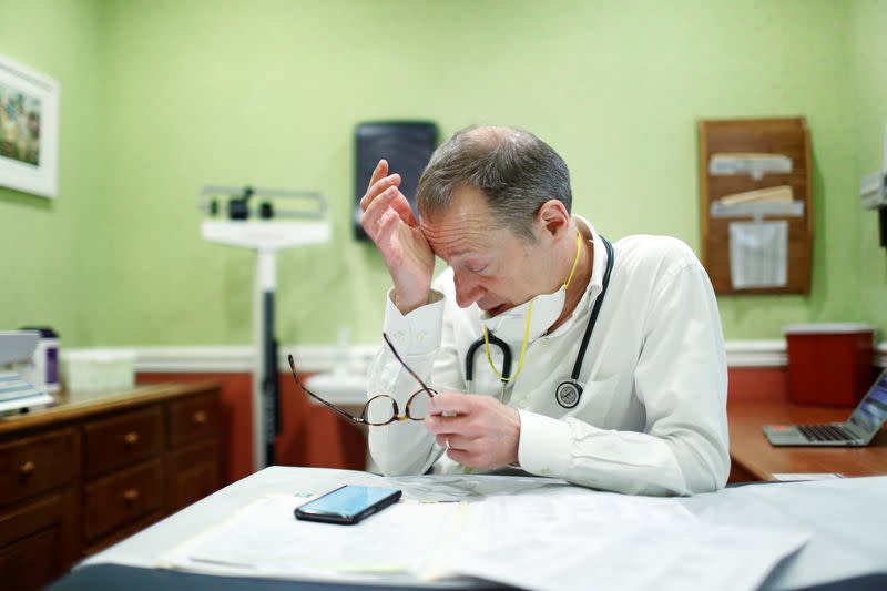 Dr Greg Gulbransen reacts after a telemedicine call while maintaining visits with both his regular patients and those confirmed to have the coronavirus disease (COVID-19) at his pediatric practice in Oyster Bay, New York