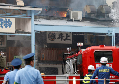 Firefighters operate at the fire site at Tokyo's Tsukiji fish market in Tokyo, Japan August 3, 2017. REUTERS/Toru Hanai