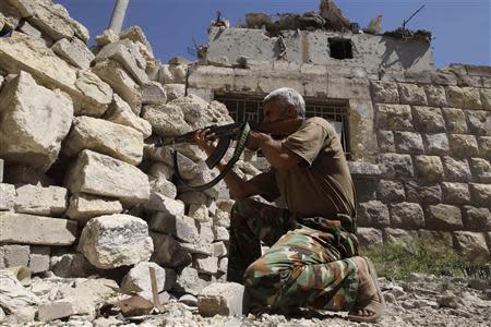 A Free Syrian Army fighter takes a position as he aims his weapon near Hanano Barracks, which is controlled by forces loyal to Syria's President Bashar al-Assad, in Aleppo September 11, 2013. REUTERS/Muzaffar Salman