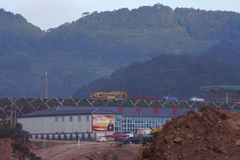 A propaganda board depicting Chinese President Xi Jinping is seen at the construction site of the Pu'er high speed rail station that is part of the China-Laos railway in Pu'er in southwestern China's Yunnan Province on Wednesday, Dec. 2, 2020. Laos, a nation of 7 million people wedged between China, Vietnam and Thailand, is opening a $5.9 billion Chinese-built railway that links China's own poor southwest to foreign markets but piles on potentially risky debt. (AP Photo/Ng Han Guan)