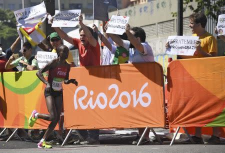 2016 Rio Olympics - Athletics - Final - Women's Marathon -Sambodromo - Rio de Janeiro, Brazil - 14/08/2016. People protest while Jemima Sumgong (KEN) of Kenya competes REUTERS/Johannes Eisele/Pool