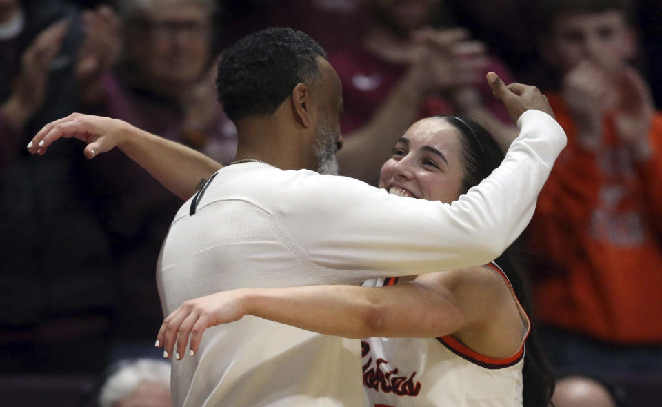 Virginia Tech's Georgia Amoore (5) and head coach Kenny Brooks embrace in the final moments of the second half of an NCAA college basketball game against North Carolina in Blacksburg Va. Sunday, Feb. 25, 2024. (Matt Gentry/The Roanoke Times via AP)