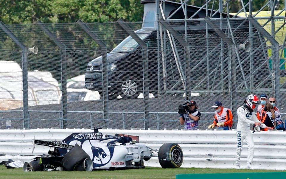 AlphaTauri's Russian driver Daniil Kvyat (R) walks away from his smashed car after a crash during the Formula One British Grand Prix at the Silverstone motor racing circuit in Silverstone, central England on August 2, 202 - AFP