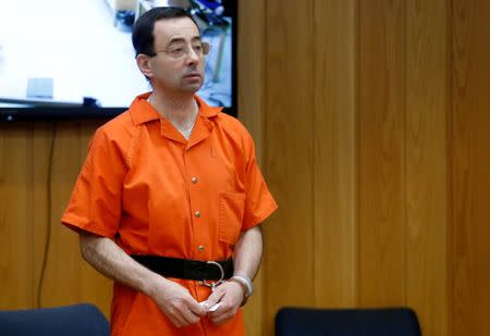 FILE PHOTO: Larry Nassar, a former team USA Gymnastics doctor who pleaded guilty in November 2017 to sexual assault charges, stands in court during his sentencing hearing in the Eaton County Court in Charlotte, Michigan, U.S., February 5, 2018. REUTERS/Rebecca Cook/File Photo