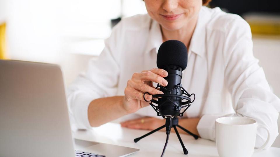 Female sitting at the table, talking on microphone.