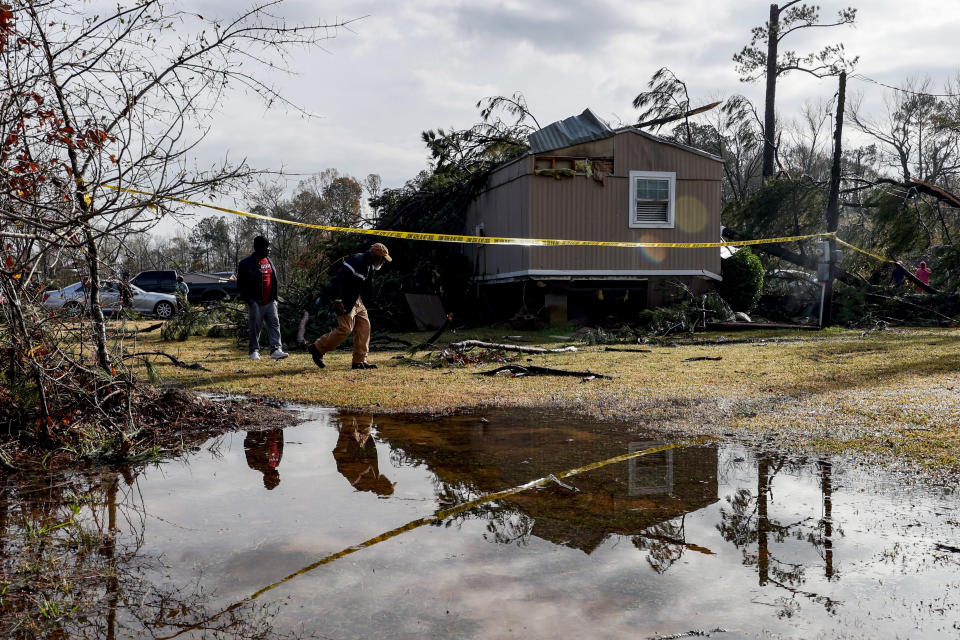 Friends and family survey damage to a house from a possible tornado Wednesday, Nov. 30, 2022, in Flatwood, Ala. (AP Photo/Butch Dill)