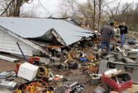 Residents search through debris after a storm ripped through Coble, Tenn. early Wednesday, Jan. 30, 2013. A large storm system packing high winds, hail and at least one tornado tore across a wide swath of the South and Midwest on Wednesday, killing one person, blacking out power to thousands and damaging homes. (AP Photo/Butch Dill)