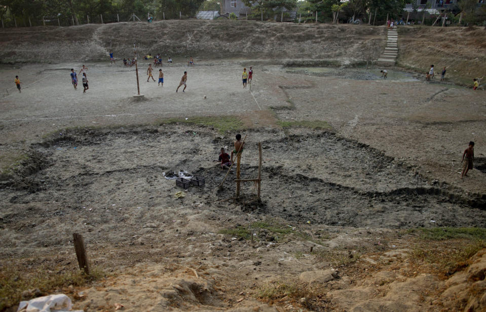 In this April 4, 2014 photo, children play soccer in a dried-up reservoir bed in Dala, suburbs of Yangon, Myanmar. Residents of Dala rely on natural fresh water ponds for water, but during Myanmar's annual dry season in April and May, there is only so much to go around.(AP Photo/Gemunu Amarasinghe)