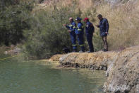 Rescuers stand next to a lake during a search operation for a six-year-old missing girl at the Xiliatos dam in Cyprus, April 22, 2019. REUTERS/Stringer