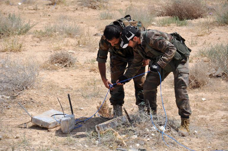 Syrian army soldiers attempt to defuse an IED in northeastern Palmyra on May 17, 2015