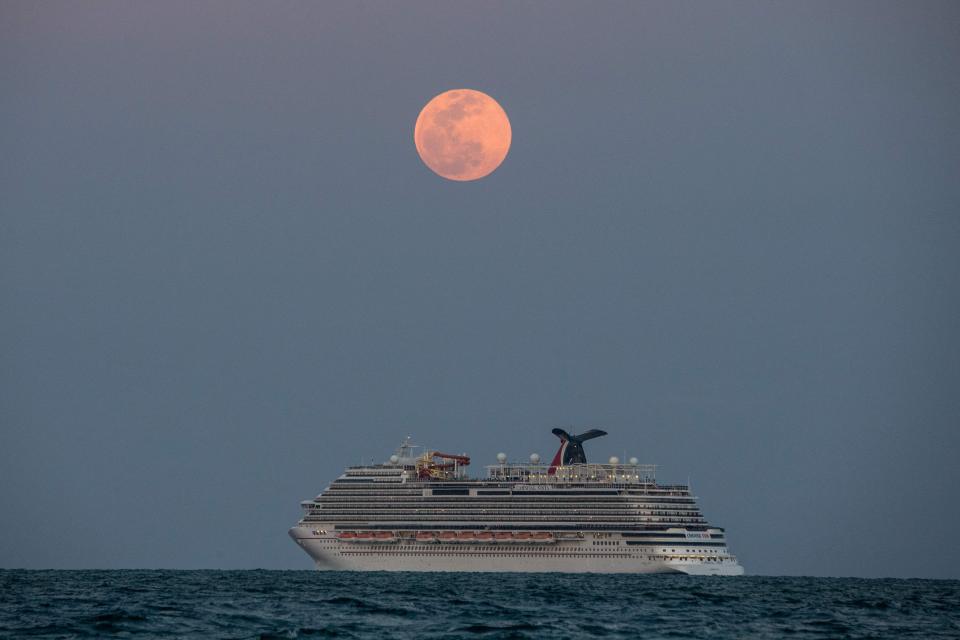 The Carnival Vista cruise ship sails during a pink super moon near Miami Beach, Fla., on April 26.