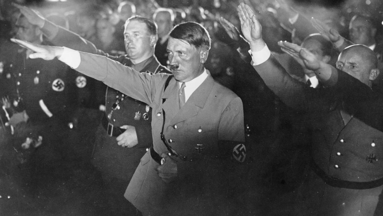 Adolf Hitler and other Nazi officials give the Nazi salute.