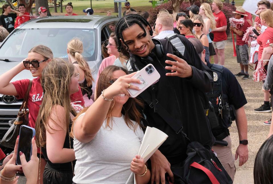 Fans greet the Alabama basketball team and staff as they arrive at Tuscaloosa National Airport Tuesday, April 2, 2024, for the trip to Phoenix to play in the Final Four. Alabama forward Jarin Stevenson (15) takes photos with the fans as he moves to the waiting airplane.