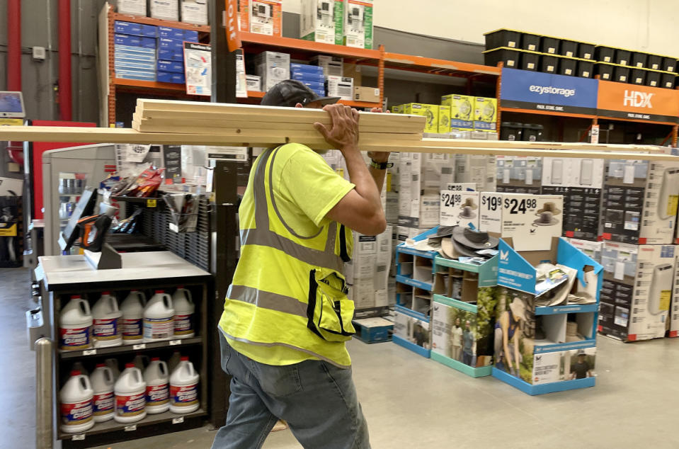 A customer carries a stack of wood at a Home Depot store.<p>Justin Sullivan/Getty Images</p>