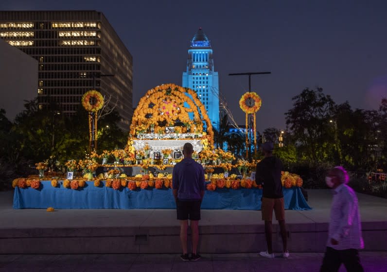 LOS ANGELES, CA -OCTOBER 28, 2020:People observe the community altar at Grand Park in downtown Los Angeles. The altar, designed by Ofelia Esparza and Rosanna Esparza, is for Covid-19 victims. Altars are popping up across L.A. for the lives lost to the coronavirus. (Mel Melcon / Los Angeles Times)