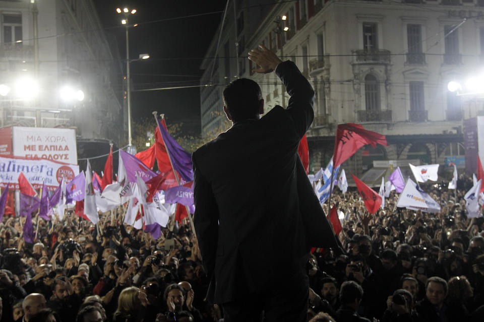 Alexis Tsipras, leader of Greece's Syriza left-wing main opposition party waves to his supporters as he arrives for a pre-election speech at Omonia Square in Athens Thursday, Jan. 22, 2015. (AP Photo/Orestis Panagiotou, Pool)