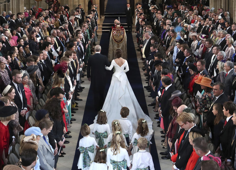 El príncipe Andrés lleva a su hija, la princesa Eugenia, al altar para su boda con Jack Brooksbank en la Capilla de San Jorge, en el Castillo de Windsor, el viernes 12 de octubre del 2018 cerca de Londres, Inglaterra. (Danny Lawson/Pool via AP)