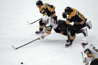 Vegas Golden Knights center Chandler Stephenson (20) dives between Boston Bruins' David Krejci (46) and Pavel Zacha (18) during the third period of an NHL hockey game, Monday, Dec. 5, 2022, in Boston. (AP Photo/Charles Krupa)