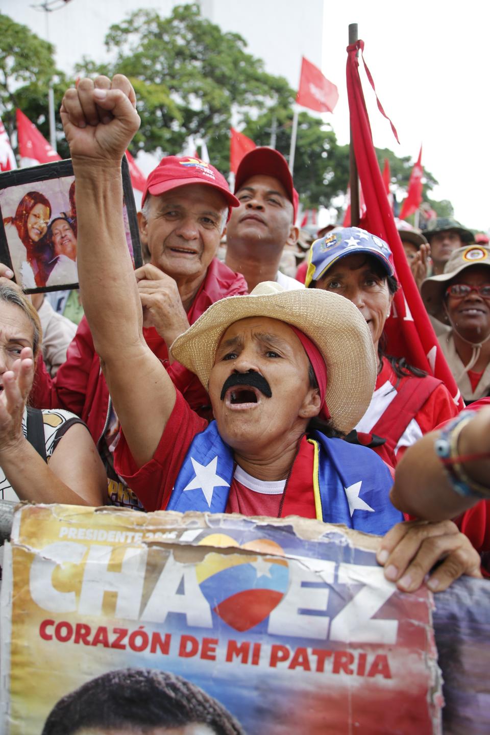 A supporter of Venezuela's President Nicolas Maduro, a fake mustache emulating that of Maduro's, takes part in a protest against Michele Bachelet, U.N. high commissioner for human rights, in Caracas, Venezuela, Saturday, July 13, 2019. Bachelet recently published a report accusing Venezuelan officials of human rights abuses, including extrajudicial killings and measures to erode democratic institutions. (AP Photo/Leonardo Fernandez)