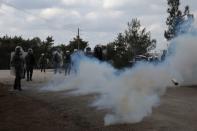 Riot police are seen amid tear gas smoke as they clash with demonstrators, who oppose the building of a new closed migrant detention centre, in the area of Diavolorema on the island of Lesbos