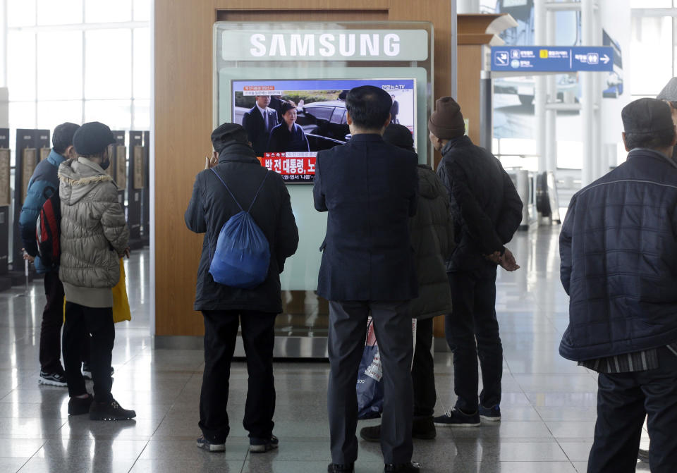 People watch a TV news program showing South Korean ousted President Park Geun-hye's arrival at prosecutors office, at Seoul Railway Station in Seoul, South Korea, Tuesday, March 21, 2017. Park said Tuesday she was "sorry" to the people as she underwent questioning by prosecutors over a corruption scandal that led to her removal from office. (AP Photo/Ahn Young-joon)