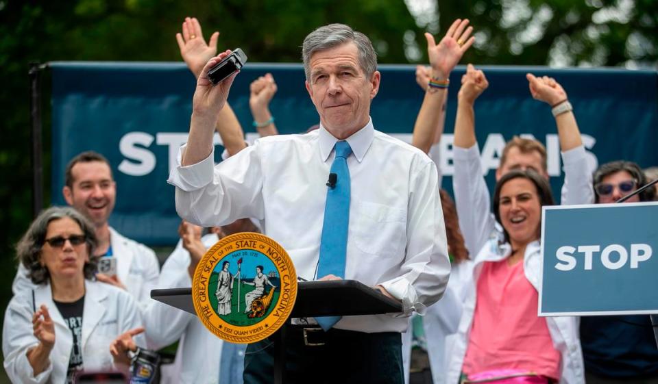 North Carolina Governor Roy Cooper displays his veto stamp after after using it and his signature to veto SB 20, legislation that would restrict abortions in North Carolina, during a public rally on the Bicentennial Mall across the State Capitol on Saturday, May 13, 2023 in Raleigh, N.C. Robert Willett/rwillett@newsobserver.com