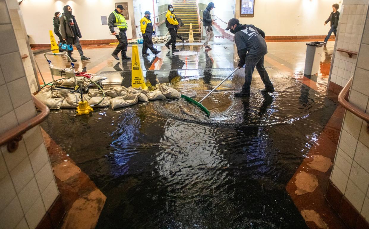 Gerardo Medina, 21, is cleaning up water inside Union Station on Tuesday, Jan. 10, 2023, in Los Angeles, CA. The torrential rain led to flooding in the pedestrian walkway inside Union Station.