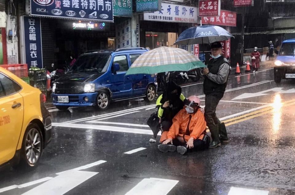 員警在大雨中為受傷女騎士撐傘，讓受傷女騎士十分感激。（記者張上耕翻攝）