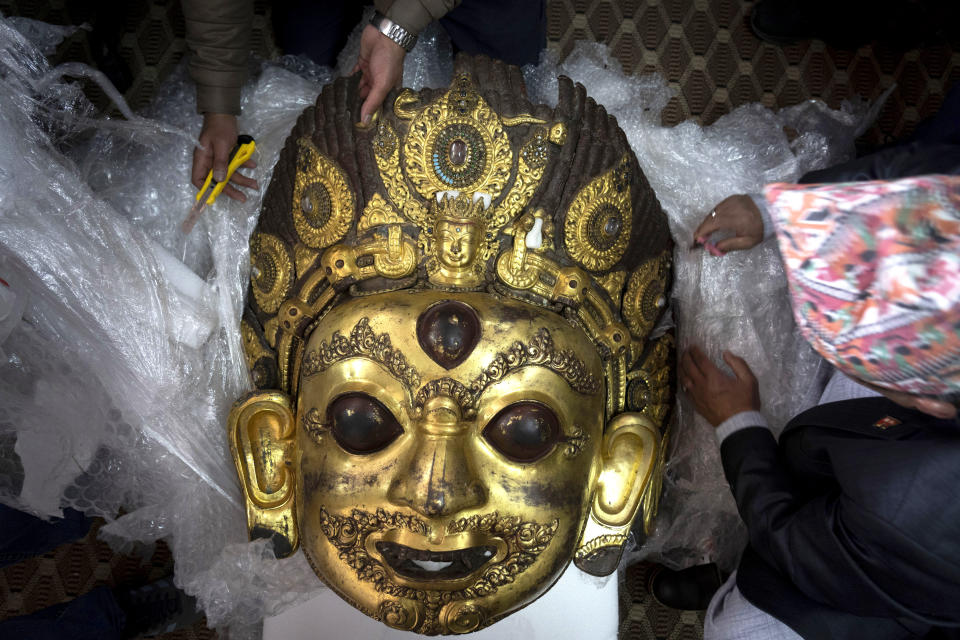 Officials unpack an artifact sent back to Nepal from a museum in the United States of America during a press conference in Kathmandu, Nepal, Wednesday, Jan. 31, 2024. Nepalese heritage activists and the Nepal government worked together to get dozens of stolen artifacts repatriated from The Rubin Museum of Art, Dallas Museum of Art, and Brooklyn Museum. Many archaeologically significant artifacts were illegally taken away from Nepal over several decades, with some finding their way into important museums in the west. (AP Photo/Niranjan Shrestha)