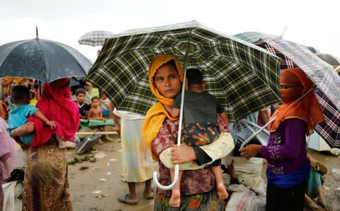 Rohingya refugees stand in heavy rain as they are held by the Border Guard Bangladesh - Credit: REUTERS/Mohammad Ponir Hossain