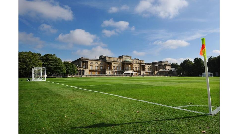 A football field with a conservatory in the distance