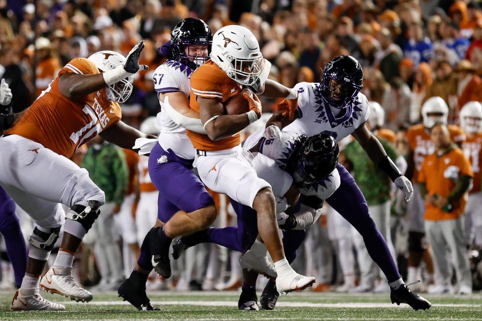 Johnny Hodges #57 of the TCU Horned Frogs and Jamoi Hodge #6 tackle Bijan Robinson #5 of the Texas Longhorns for a loss in the first half of the game at Darrell K Royal-Texas Memorial Stadium on Nov. 12, 2022, in Austin, Texas.
