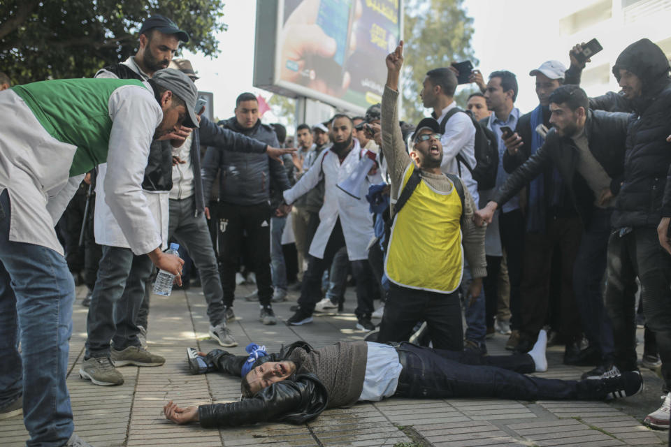 An injured protesting teacher is tended to by fellow protesters after security forces used water cannons and batons to disperse a demonstration in Rabat, Morocco, Wednesday, Feb. 20, 2019. The thousands of protesters, many wearing white teachers' robes, came from around Morocco to Rabat to seek salary raises and promotions and protest the limited opportunities for low-ranking teachers, who earn an average of 400 euros ($454) a month. (AP Photo/Mosa'ab Elshamy)