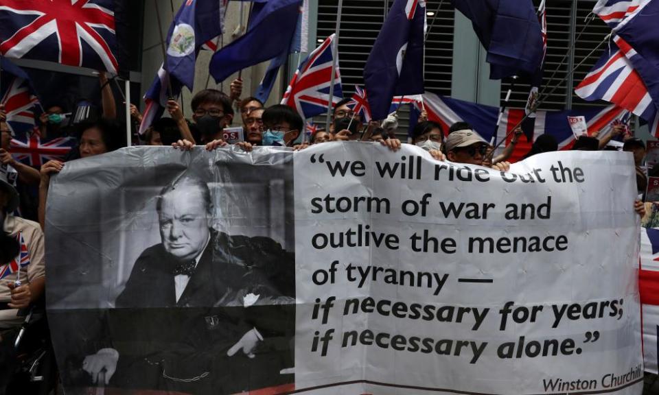 Anti-government protesters hold up banners and union flags outside the British consulate in Hong Kong.