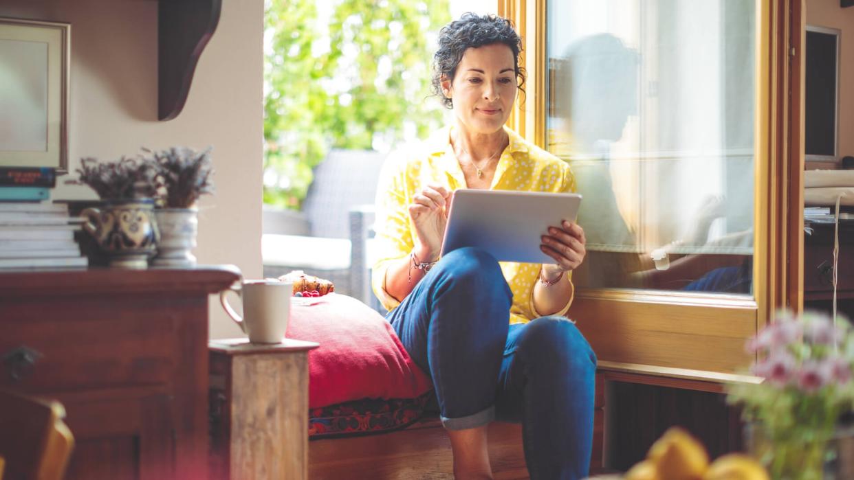 Mature woman is purchasing online at home.