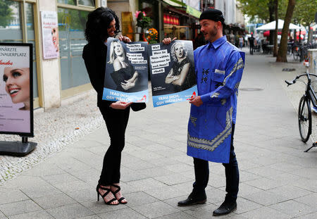 German drag artists Jacky-oh Weinhaus (L) and Buffalo Meus pose with posters as they parody the anti-Immigrant Alternative for Germany (AfD) party by setting up a fictional party called Travestie for Germany (TfD) in Berlin, Germany, August 24, 2017. REUTERS/Fabrizio Bensch