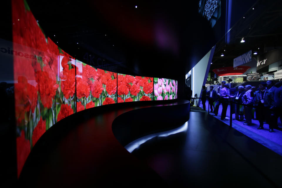 FILE - In this Jan. 7, 2014 file photo, attendees looks at the installation made with curved OLED displays at the Panasonic booth during the International Consumer Electronics Show in Las Vegas. Panasonic reports quarterly earnings on Tuesday, Feb. 4, 2014. (AP Photo/Jae C. Hong, File)