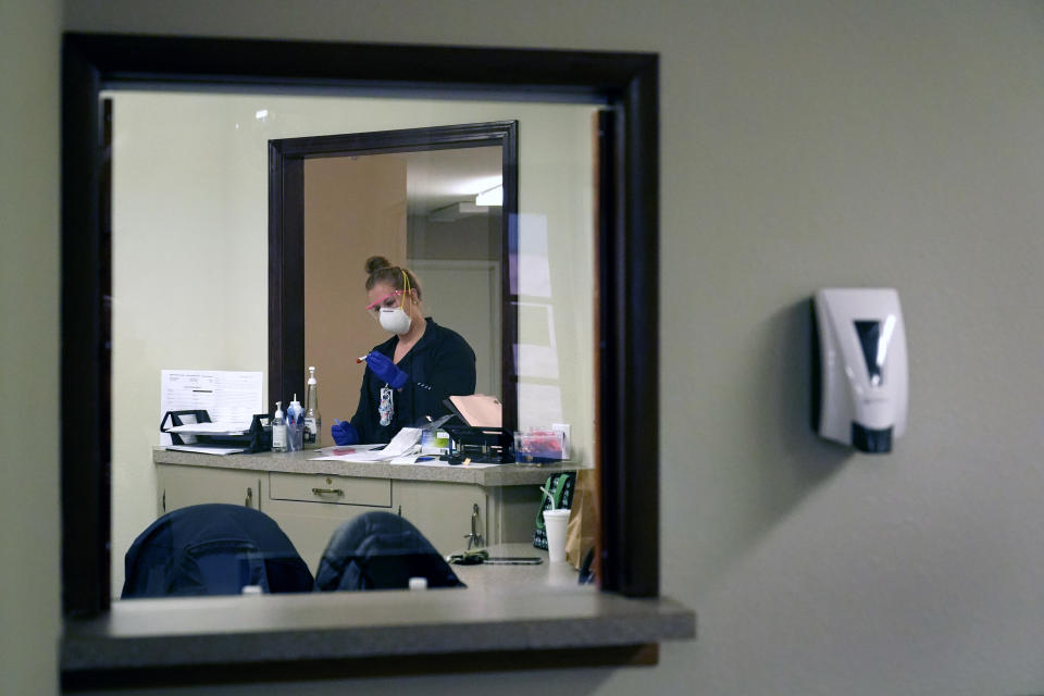 Registered nurse Brenna Smith prepares a COVID-19 test for a drive-up patient at Scotland County Hospital Tuesday, Nov. 24, 2020, in Memphis, Mo. As new cases of coronavirus rise each day throughout the U.S, rural parts of America are being particularly hard hit. (AP Photo/Jeff Roberson)