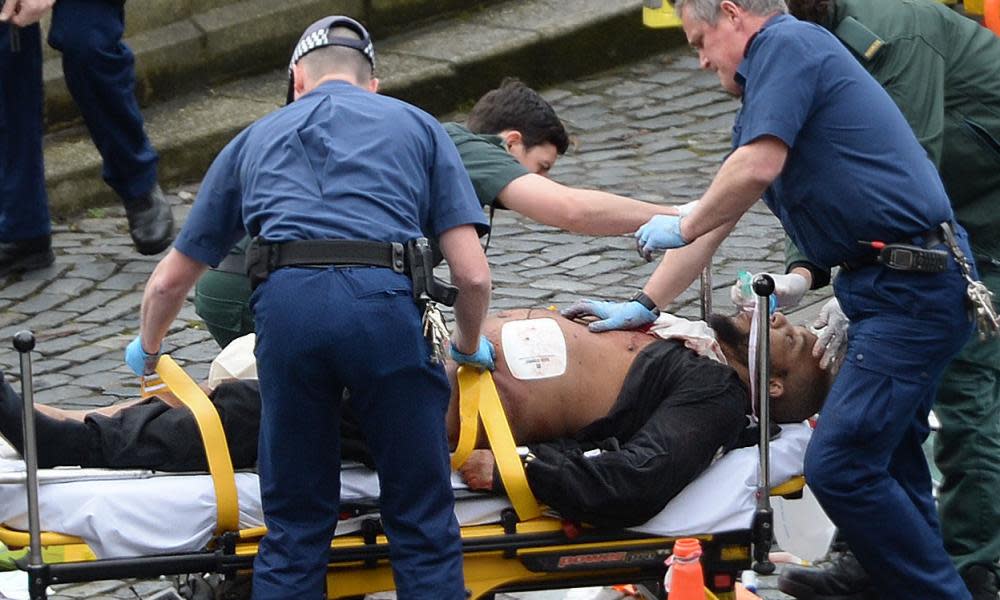 Emergency services outside the Palace of Westminster treat the attacker, who has been named as Khalid Masood.