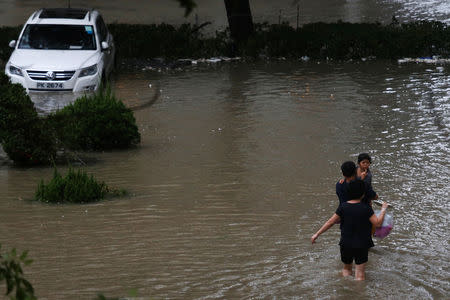 Residents wade though flood water as high waves hit the shore at Heng Fa Chuen, a residential district near the waterfront, following Typhoon Mangkhut in Hong Kong, China September 16, 2018. REUTERS/Bobby Yip