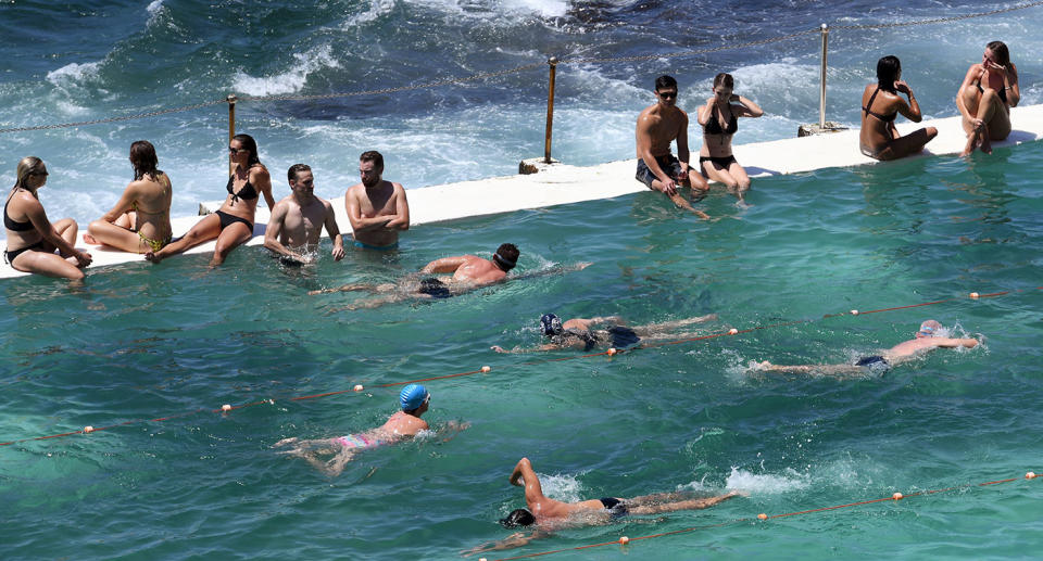 People watch others swim in a pool at Sydney's Bondi Beach