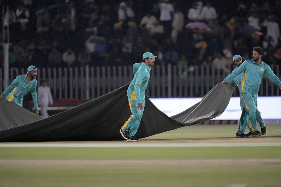 Ground staff cover the pitch and other areas as rain stop the play of first T20 cricket match between Pakistan and New Zealand, in Rawalpindi, Pakistan, Thursday, April 18, 2024. (AP Photo/Anjum Naveed)