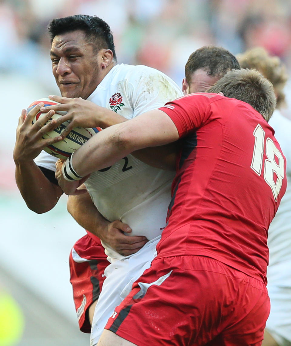 England's Mako Vunipola. left, is grappled by Wales's Rhodri Jones during the Six Nations Rugby Union match between England and Wales at Twickenham stadium in London Sunday, March, 9, 2014. (AP Photo/Alastair Grant)