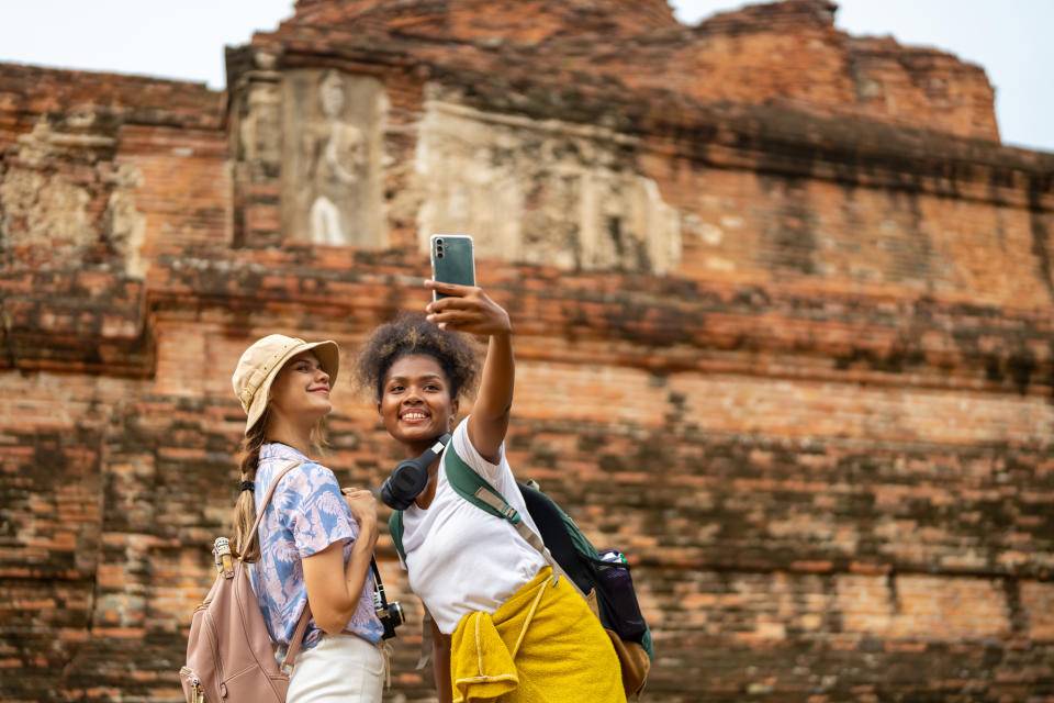 two people taking a photo together in front of a historical site