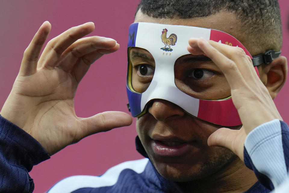 FILE - France's Kylian Mbappe adjusts his face mask during a training session in Leipzig, Germany, on June 20, 2024. Kylian Mbappé has had more masks than goals at Euro 2024. Widely regarded as the heir to Lionel Messi and Cristiano Ronaldo as soccer's biggest icon, the France striker is struggling with his peripheral vision due to the protective face covering he has been fitted with since breaking his nose at the start of the European Championship. (AP Photo/Hassan Ammar)