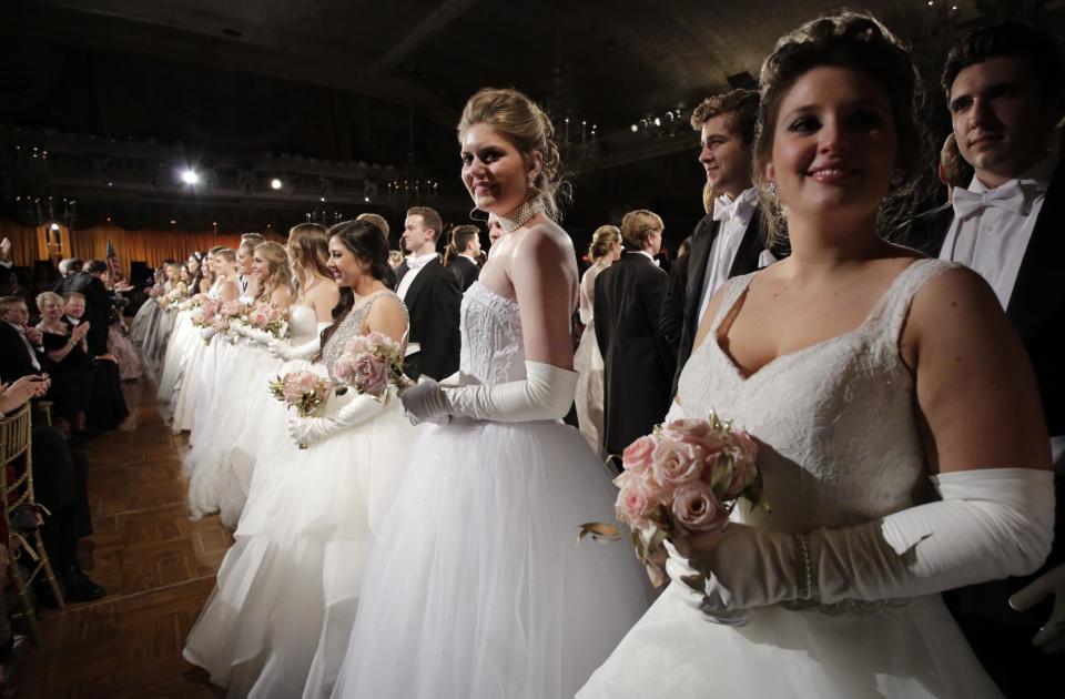 In this Thursday, Dec. 29, 2016 photo, debutantes and their escorts line up before a waltz begins at the International Debutante Ball in New York. (AP Photo/Mark Lennihan)