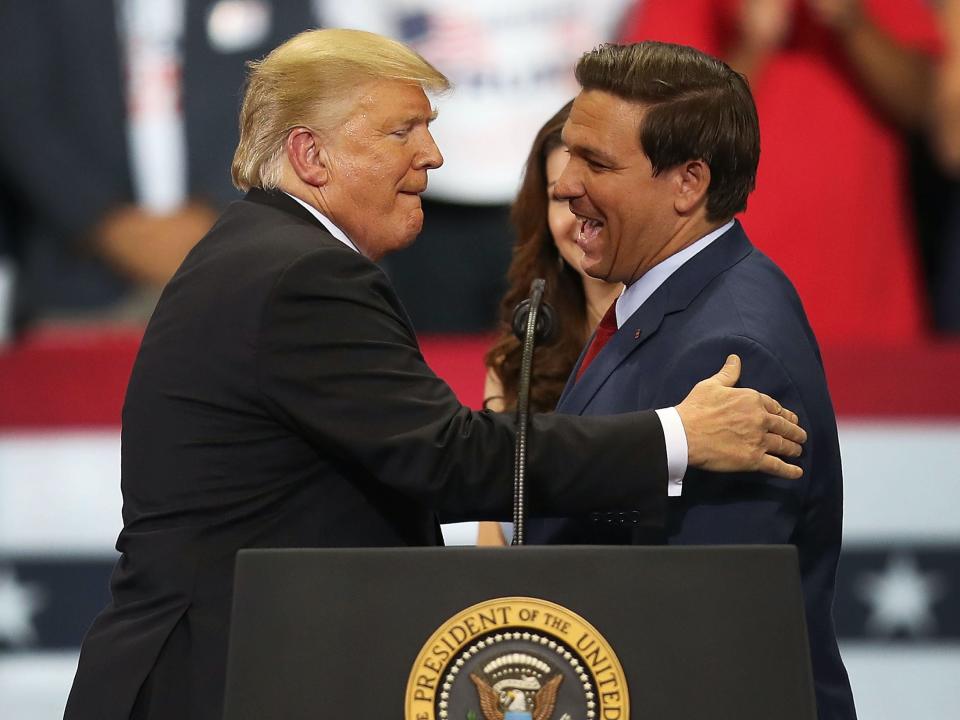 Then-President Donald Trump greets then-Florida Republican gubernatorial candidate Ron DeSantis during a campaign rally at the Hertz Arena on October 31, 2018 in Estero, Florida.