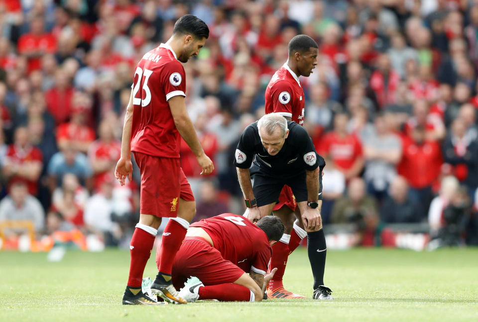 <p>Referee Martin Atkinson talks to Liverpool’s Dejan Lovren as he is down injured</p>